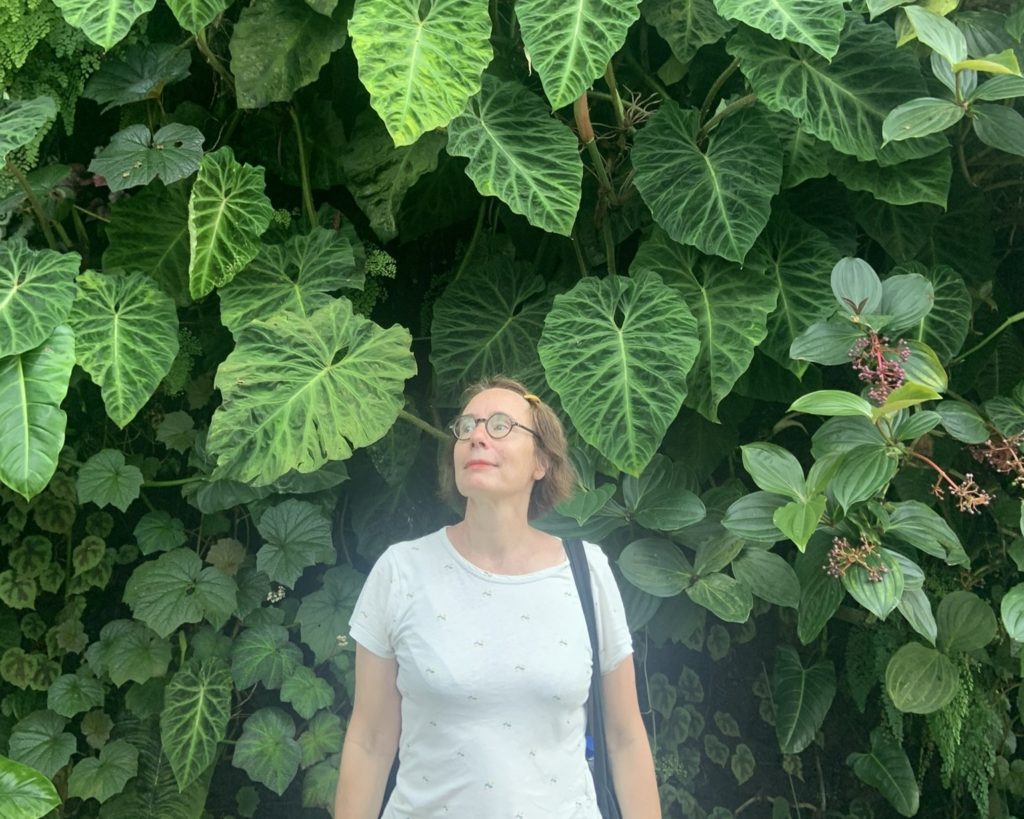 Estelle Lefrancois, jardinier-paysagiste urbaine, devant un mur végétal luxuriant