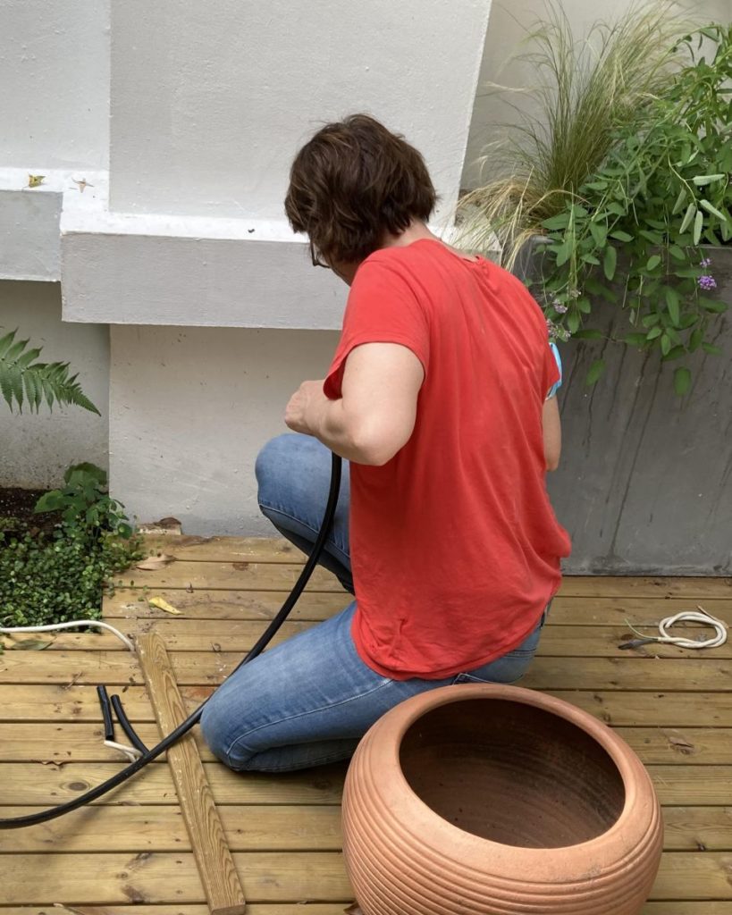 Estelle Lefrancois, jardinier-paysagiste, installant un système d’arrosage automatique sur une terrasse urbaine